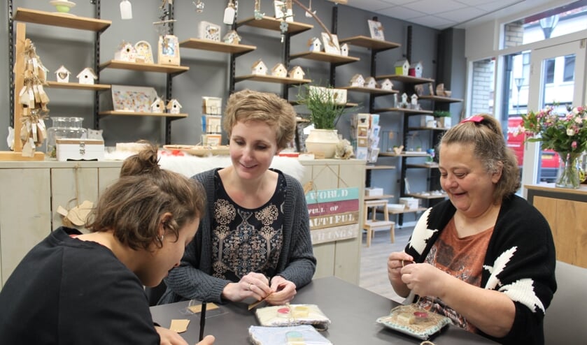 Zamani, Marianne (begeleider ’s Heeren Loo) en Pascal pakken de zelfgemaakte producten in voor de verkoop. Foto: PR