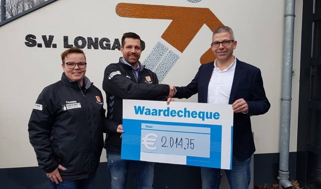 Olga Doppen en Roy van Melis overhandigen de cheque aan jeugdvoorzitter Roy Baks. Foto: PR