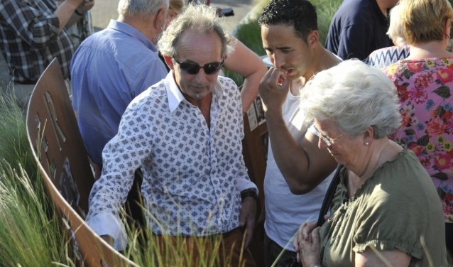 Bezoekers zoeken naar bekende oud-DRU-arbeiders tussen de De geëmailleerde portretten. Foto: PR