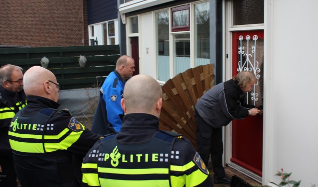 Sloten worden vervangen door de slotenmaker onder toeziend oog van de politie. Foto: Marlous Velthausz