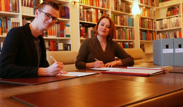 Wethouder Mathijs ten Broeke en uitgever Winnie Urban ondertekenen overdracht archief WalburgPers naar RAZ. Foto: PR