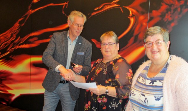 Diny Hissink (m.) en Willy Kobussen ontvangen van bestuurder Gerrit Vlogman hun gouden Zonnebloem-onderscheiding. Foto: PR