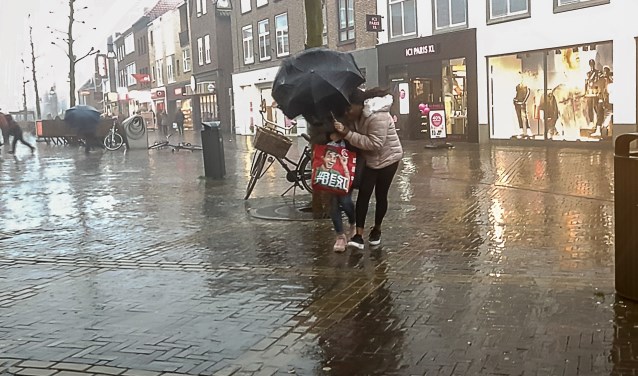 Deze dames trotseerden de regen en windstoten, gebult onder de paraplu die enkele ogenblikken later toch zou omklappen. Foto: Burry van den Brink