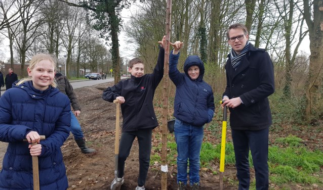 Wethouder Bart Porskamp plant, samen met vlnr. Sara, Niek en Krijn, een kersenboom. Foto: Kyra Broshuis