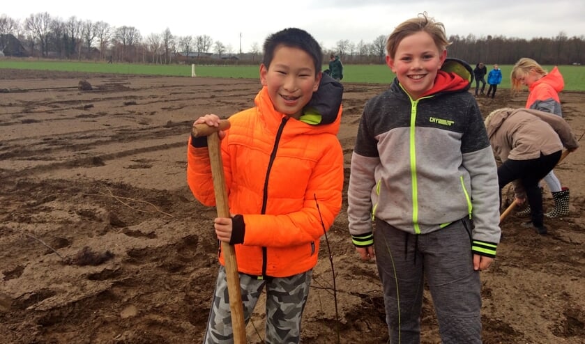 Jing en Finn plantten honderd struiken aan de Krommedijk in Hengelo tijdens Boomfeestdag. Foto: Diny Vink