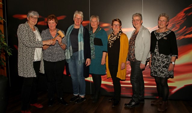 Gerrie Rap draagt voorzittershamer over aan Trees Offenberg die nu met Toos van Asselt, Ria Ruessink, Ria van Malsen, Janny Lenselink en Hennie Wijers het bestuur van Mozaïek vormt. Foto: Liesbeth Spaansen