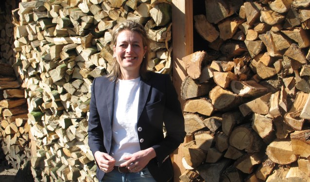 Ilse Saris bij het hout dat ze deels zelf heeft gekloofd. Foto: Bernhard Harfsterkamp
