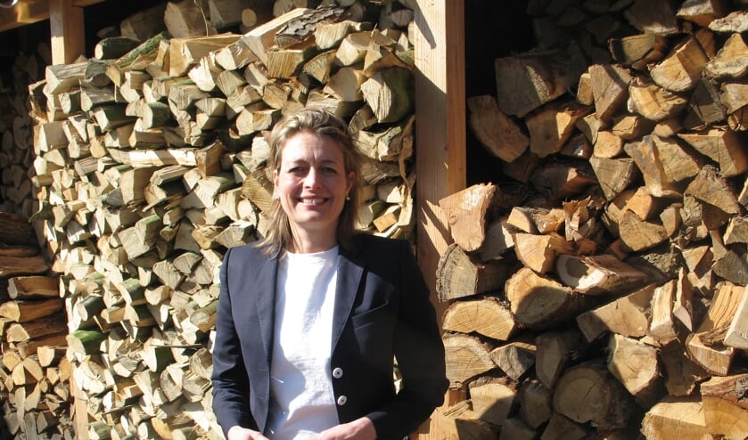 Ilse Saris bij het hout dat ze deels zelf heeft gekloofd. Foto: Bernhard Harfsterkamp
