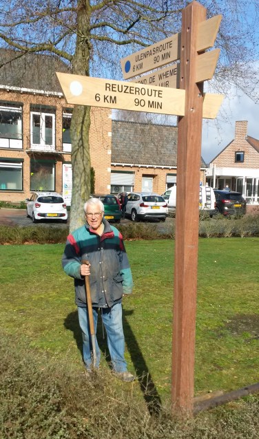 Gerard, voorzitter Stichting Wandelpaden, bij de vernieuwde routepaal. Foto:Theo Koele