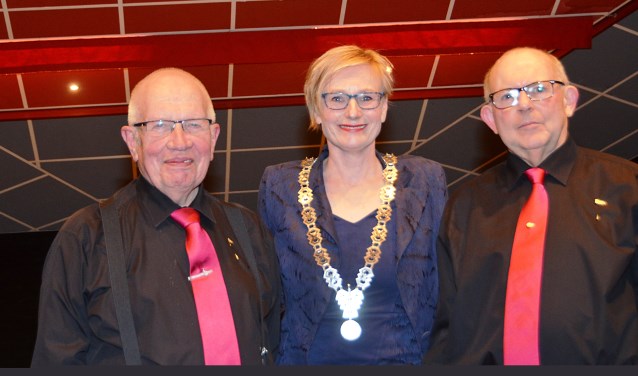 Jubilarissen van Harmonie Prinses Juliana Gert Klein Wentink (l .) en Johan Roenhorst (r.) werden gehuldigd door burgemeester Besselink. Foto: Arno Wolsink