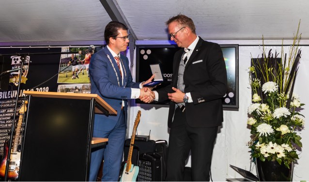 Burgemeester Van Oostrum reikt de Koninklijke Erepenning uit aan voorzitter Marc Dieperink. Foto: Marcel ter Bals, Orangepictures