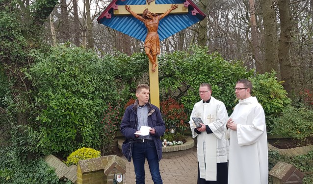 Buurtbewoner Ard Schenk vertelt over de geschiedenis van het kruisbeeld. Naast hem pastoor Den Hartog.
