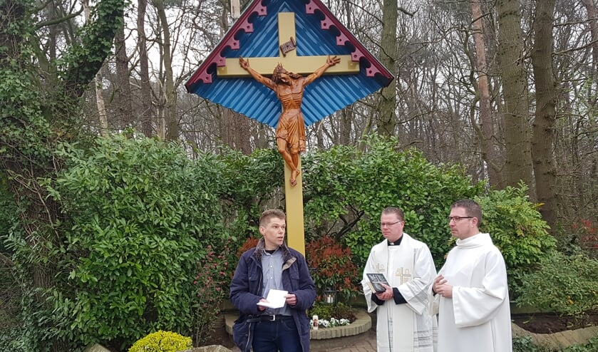 Buurtbewoner Ard Schenk vertelt over de geschiedenis van het kruisbeeld. Naast hem pastoor Den Hartog.