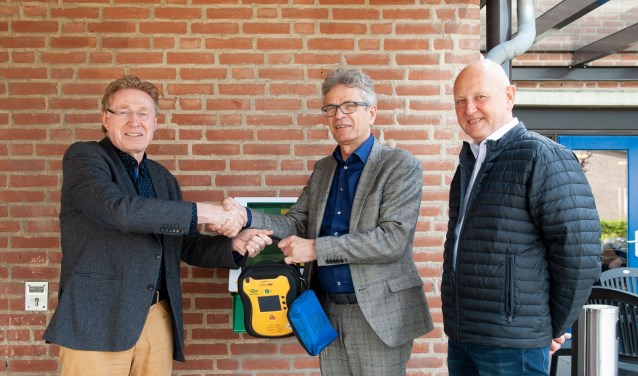 Johan G. Esendam, voorzitter van Hart4Winterswijk, Marcel Duvigneau, bestuurder van Marga Klompé en Wim Kos van Hart4Winterswijk staan. Zij staan voor de AED bij Pronsweide. Foto: Vanessa Wassink, Hip & Stijl fotografie