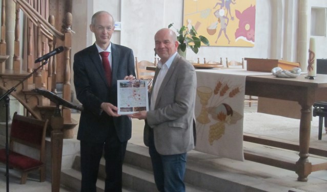 Willem van den Berg, voorzitter van de stichting Vrienden van de Jacobskerk overhandigde eerste exemplaar folder Museum kwartet aan wethouder Aalderink. Foto: Bernhard Harfsterkamp