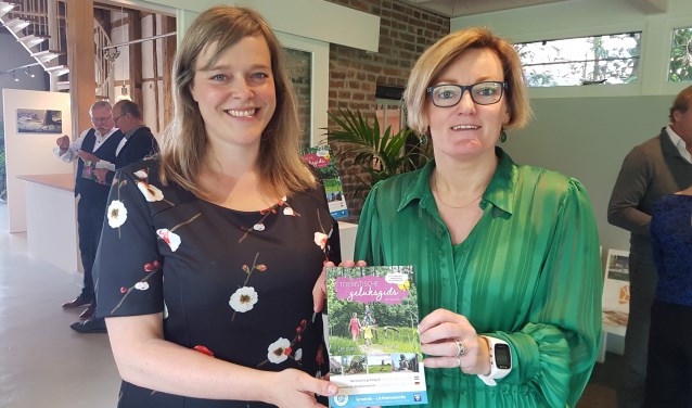Meike Prollius (l), toeristisch coördinator van de gemeente Oost Gelre, en wethouder Marieke Frank met de nieuwe Geluksgids. Foto: Kyra Broshuis