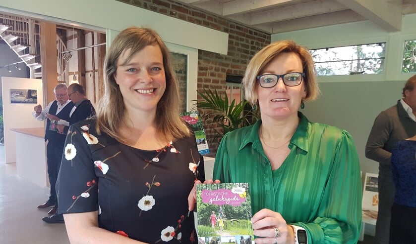 Meike Prollius (l), toeristisch coördinator van de gemeente Oost Gelre, en wethouder Marieke Frank met de nieuwe Geluksgids. Foto: Kyra Broshuis