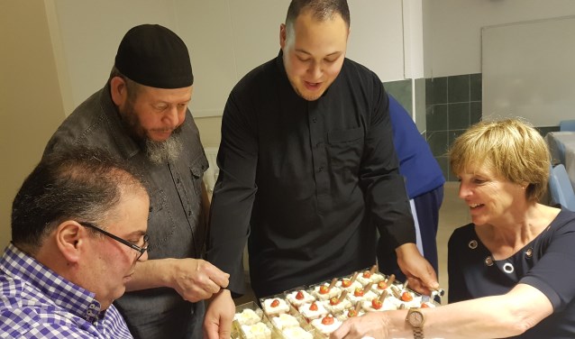 Burgemeester Bronsvoort krijgt van kok Yassin een dessert aangeboden. Links Boukhiyar Taouil. Foto: Kyra Broshuis