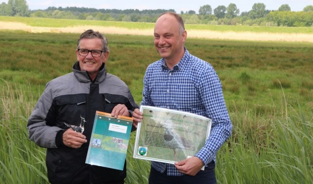 Boerenlandvogelvrijwilliger Fons Roording (l) ontvangt glazen kievit en een oorkonde uit handen van Arjan Vriend, directeur-bestuurder Stichting Landschapsbeheer Gelderland. Foto: SLG