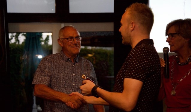 Michiel feliciteert zijn vader Tonnie Krabbenborg met de gouden fluit onder toeziend oog van burgemeester Bronsvoort. Foto: Lotte Bekkenutte