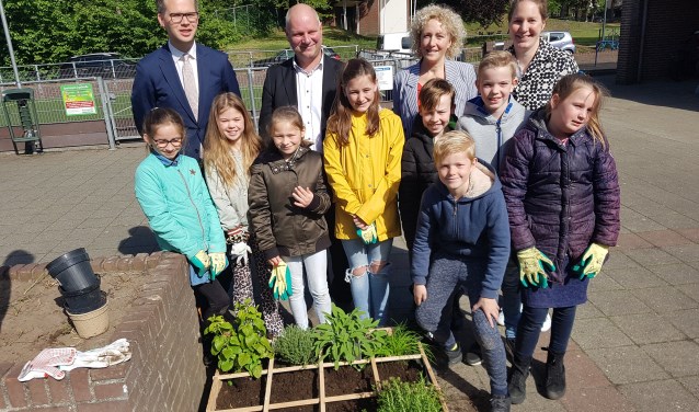 Het kruidentuintje van de Watermolenschool met op de achtergrond vlnr wethouder Bart Porskamp, Peter Schrijver van het Waterschap Rijn IJssel, Leontien Witjes van Staring Advies en juf Rosalie. Foto: Kyra Broshuis