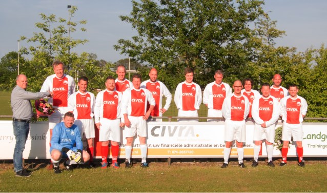 Omringd door leden van beide teams in de nieuwe outfit ontvangt Arjan Wanschers van Civra als dank een bloemetje uit handen van de SVBV sponsorcommissie. Foto: PR.