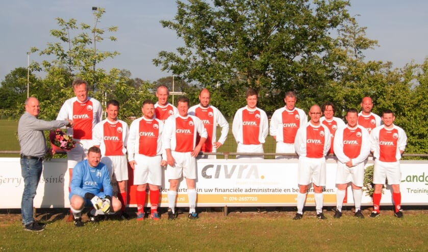 Omringd door leden van beide teams in de nieuwe outfit ontvangt Arjan Wanschers van Civra als dank een bloemetje uit handen van de SVBV sponsorcommissie. Foto: PR.