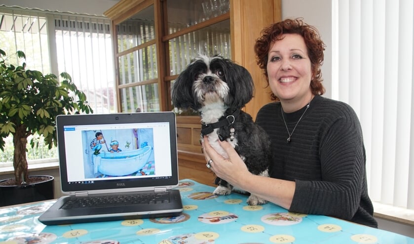 Bettina IJzendoorn, met een afbeelding van het boek op de pc, en met haar hond, die in een verhaal Guusje heet. Foto: Frank Vinkenvleugel