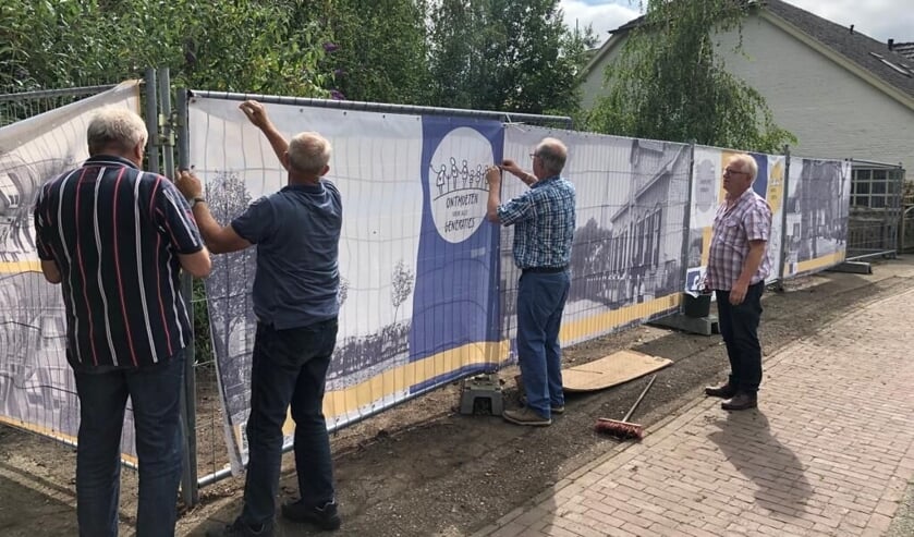 Vrijwilligers verwijderen achter De Engel het woekerende onkruid en voorzien de bouwhekken van oude beelden. Foto: PR