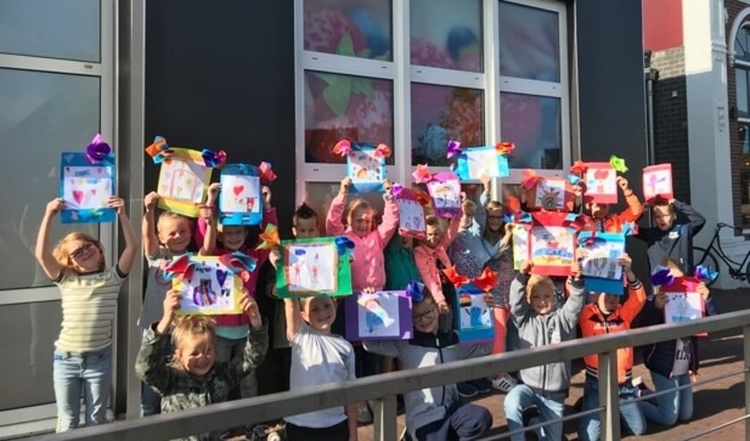 Groep 3 met de eigengemaakte tekeningen om uit te delen aan andere mensen en zo geluk door te geven. Foto: PR