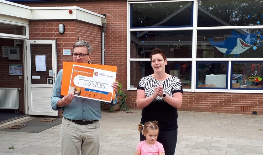 Directeur Jan van der Horst toont de cheque met het enorme bedrag. Rechts Marloes en dochtertje Fleur. Foto: PR