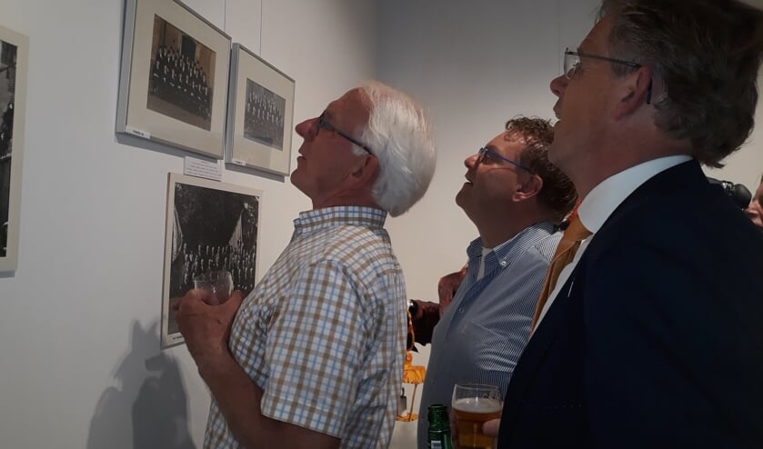 Bekenden zoeken op oude foto's. Rechts Hans Smit. Foto: Sis Huiskamp