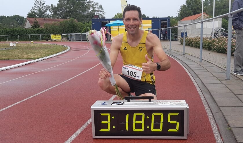 Bjorn Demkes poseert bij de klok met zijn geweldige marathon-eindtijd. Foto: Geert Wevers