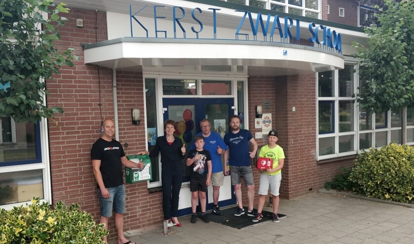 Andres Mol, Willemien van Uhm, Vince Bouwmeester, Jan Halfman, Maarten Gotink en Boet ter Bogt (v.l.n.r.) bij de nieuwe AED aan de Schoolstraat bij de Kerst Zwartschool. Foto: PR.