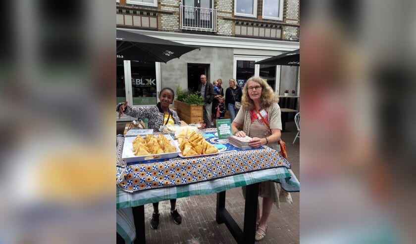 Vol trots laat een van de deelnemers aan het Taalcafé de baksels zien. Foto: eigen foto