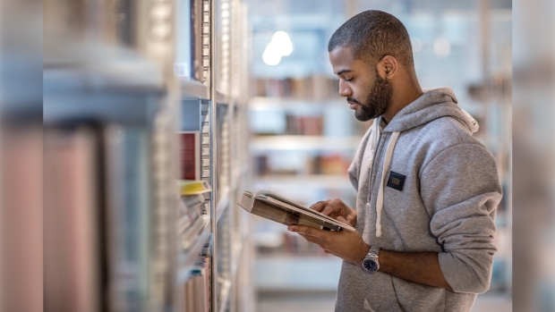 Handsome afro american university student studying alone in a campus library