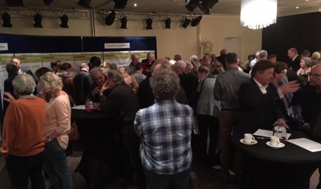 Bezoekers van de inloopavond laten zich informeren.