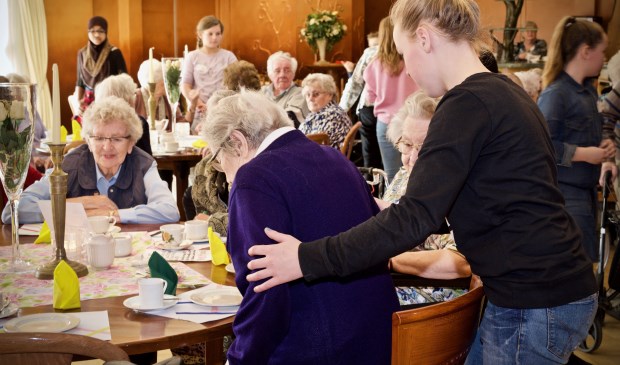 Een leerling van De Springschans helpt één van de bewoonsters van de Viva! Zorggroep bij het gaan zitten.
Foto: Stip Fotografie