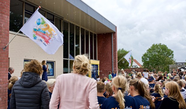 De feestvlag werd gehesen terwijl de kinderen met bellenblaas de vlag omhoog bliezen