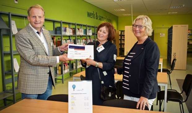 De cheque wordt uitgereikt door Ko Hemminga (Rabobank) aan Jeanette Braam en Ted Herkes (Bibliotheek Heiloo)