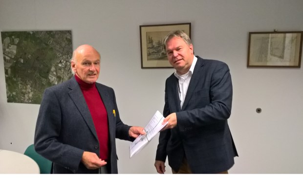 Namens de bewoners overhandigt Carl Müller een petitie aan wethouder Rob Opdam.