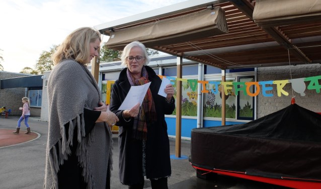 Teamleider Angelique Besseling van De Waerden (links) ontvangt een jubileumcadeau namens de gemeente Heiloo van wethouder jeugdzorg Elly Beens (rechts).