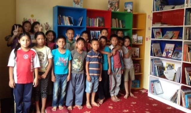 Nepalese kinderen in de blbliotheek van het tehuis