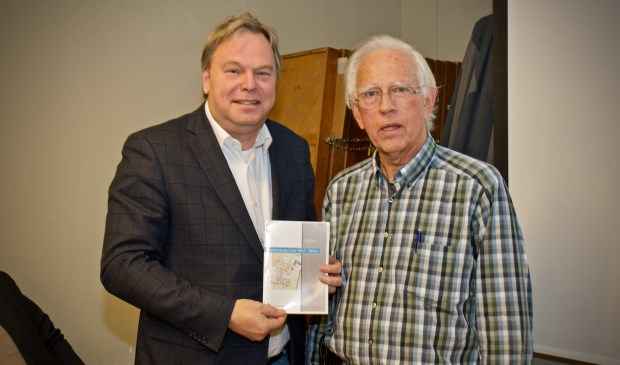 Harm Hofman reikt het rapport 'Energieopslag Oude Werf Heiloo' uit aan wethouder Rob Opdam.