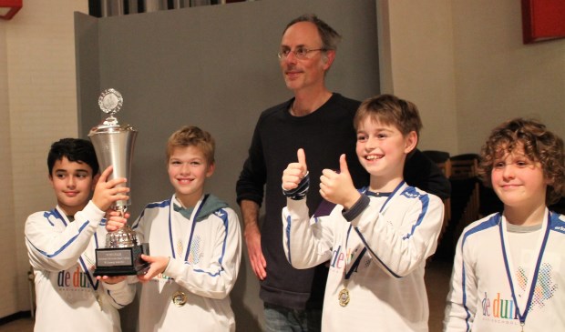 Schaakteam De Duif 1 (v.l.n.r. Darien, Quinten, Jasper en Sil) onder leiding van ‘schaakvader’ Asaf Lahat won de wisselbeker op het Schoolschaaktoernooi van SV Oppositie.