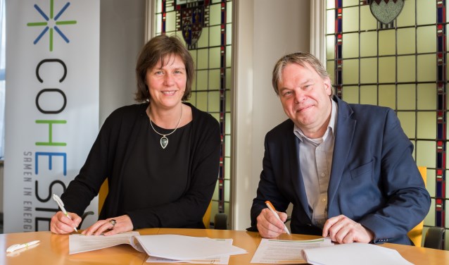 Voorzitter Wilma Eerenstein van COHESIE en wethouder Rob Opdam ondertekenen de overeenkomst.