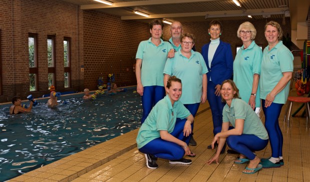 Suzan en Arth Loos temidden van hun team van zwembad Loos.