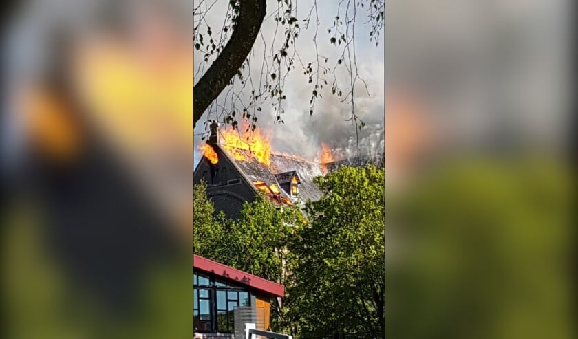 Uitslaande vlammen op het dak van de Corneliuskerk.