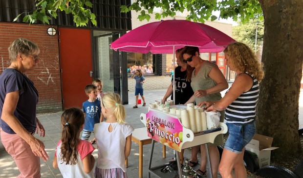 De ouders van de ouderactiviteitencommissie voorzien de leerlingen van een overheerlijk ijsje.