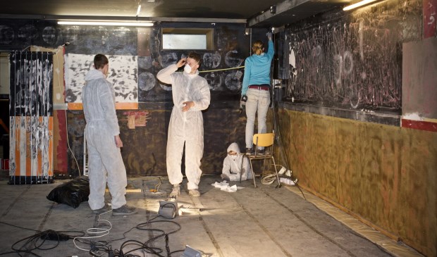 Mannen in witte pakken in Het Brunogebouw.